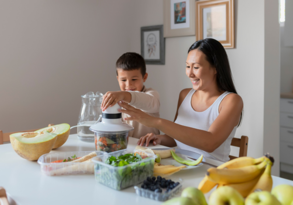 family juicing and eating salad around a table