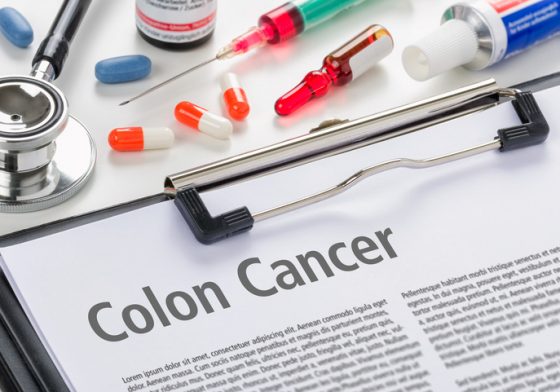 pills, needle, stethoscope and colon cancer information document