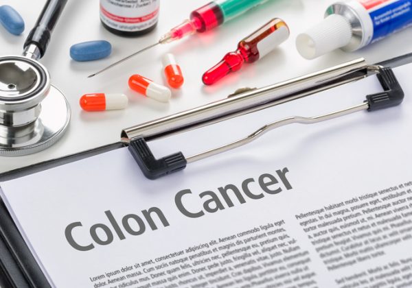 pills, needle, stethoscope and colon cancer information document