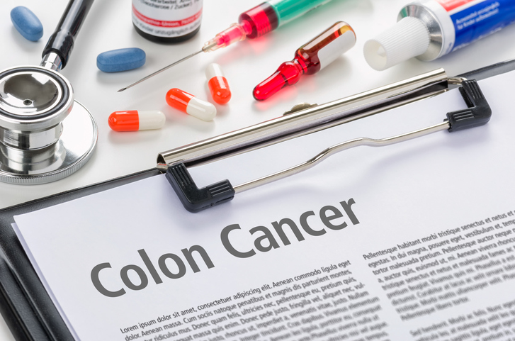 pills, needle, stethoscope and colon cancer information document