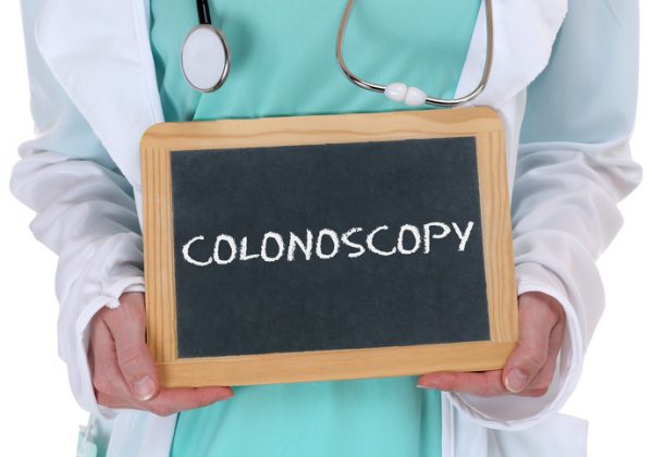 Doctor holding chalkboard with colonoscopy written on it