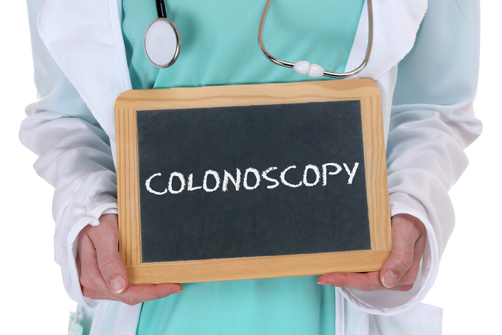 Doctor holding chalkboard with colonoscopy written on it