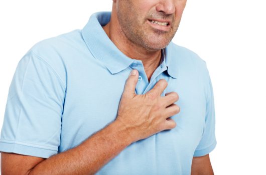 man clutching chest experiencing acid reflux