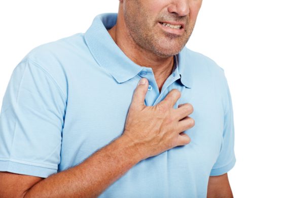 man clutching chest experiencing acid reflux