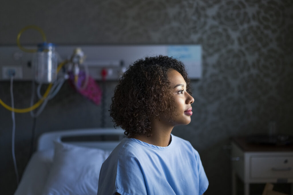 A young woman with colon cancer in a doctor's office waiting to get a colonoscopy.